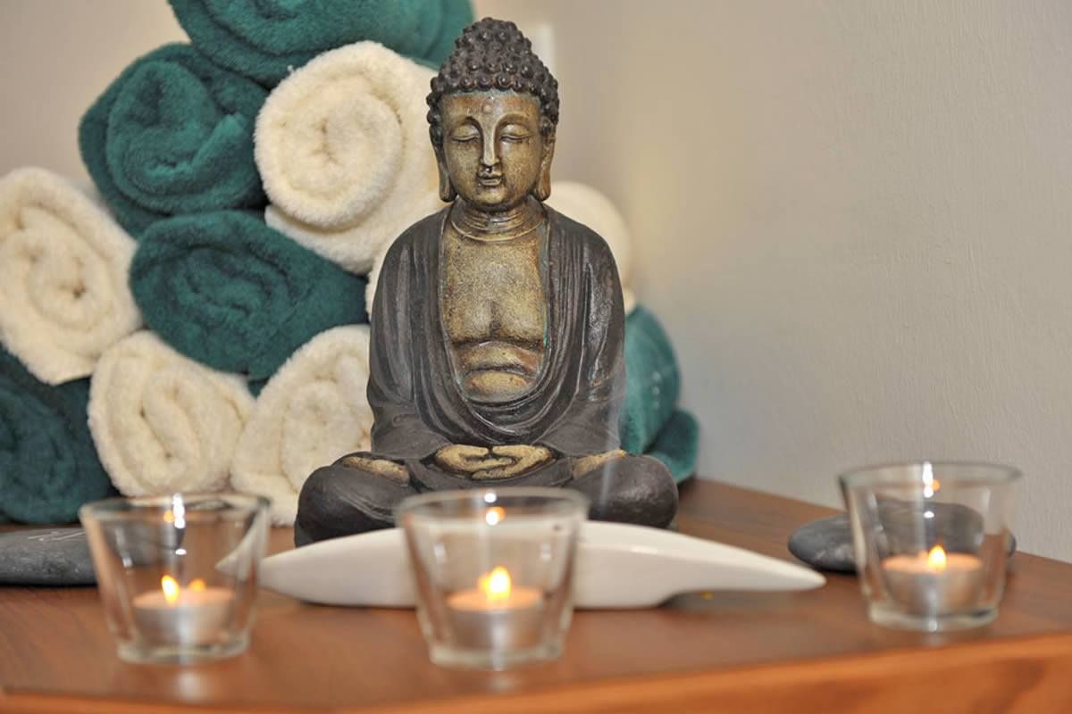 Buddha-Figur mit Kerzen in einem Ruheraum. Fühlen Sie sich wie neugeboren nach eine Beauty-Behandlung im Wellnesshotel Seeblick